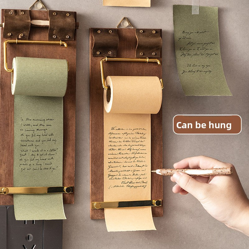 Two memo boards hung on a wall, one with green paper and one with kraft paper, a hand writing a note