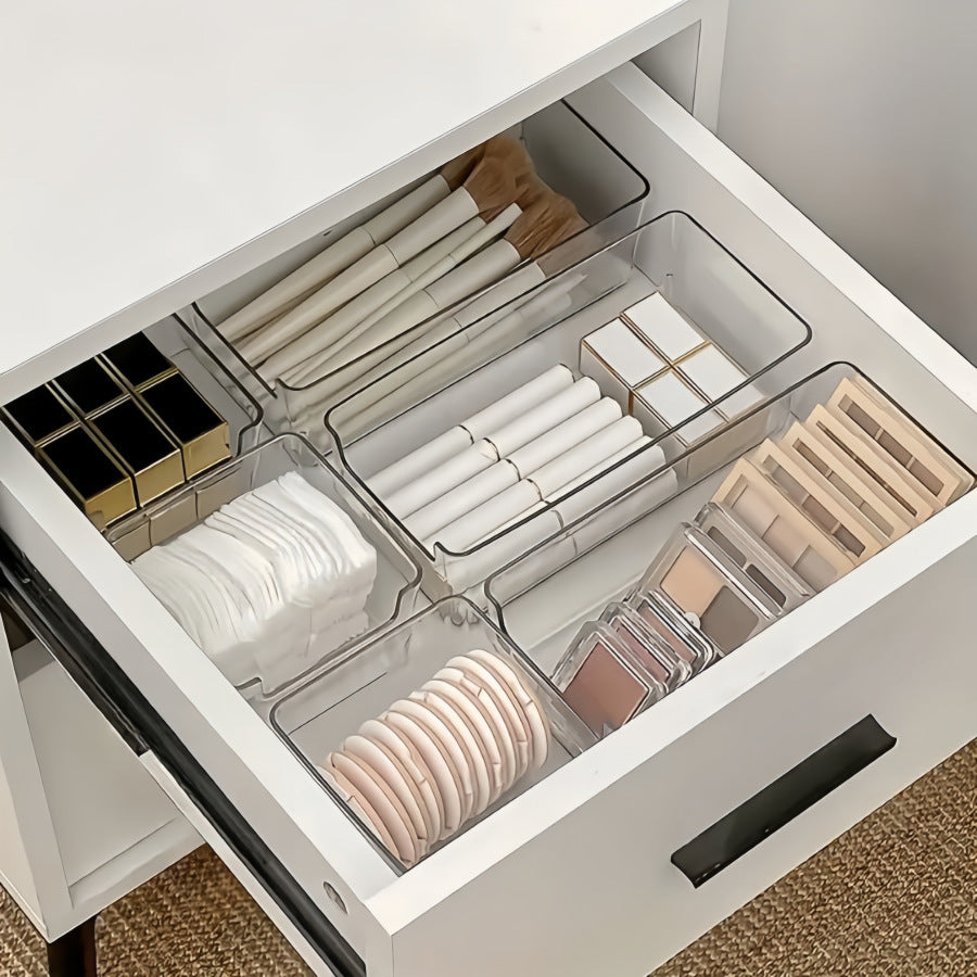Clear small and medium bins in a vanity drawer holding brushes, lipsticks and cotton pads