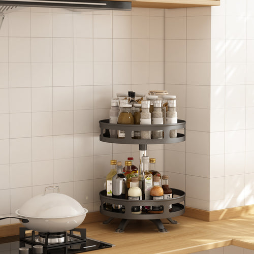 Black two-tier rotating spice rack on a kitchen counter beside the stove