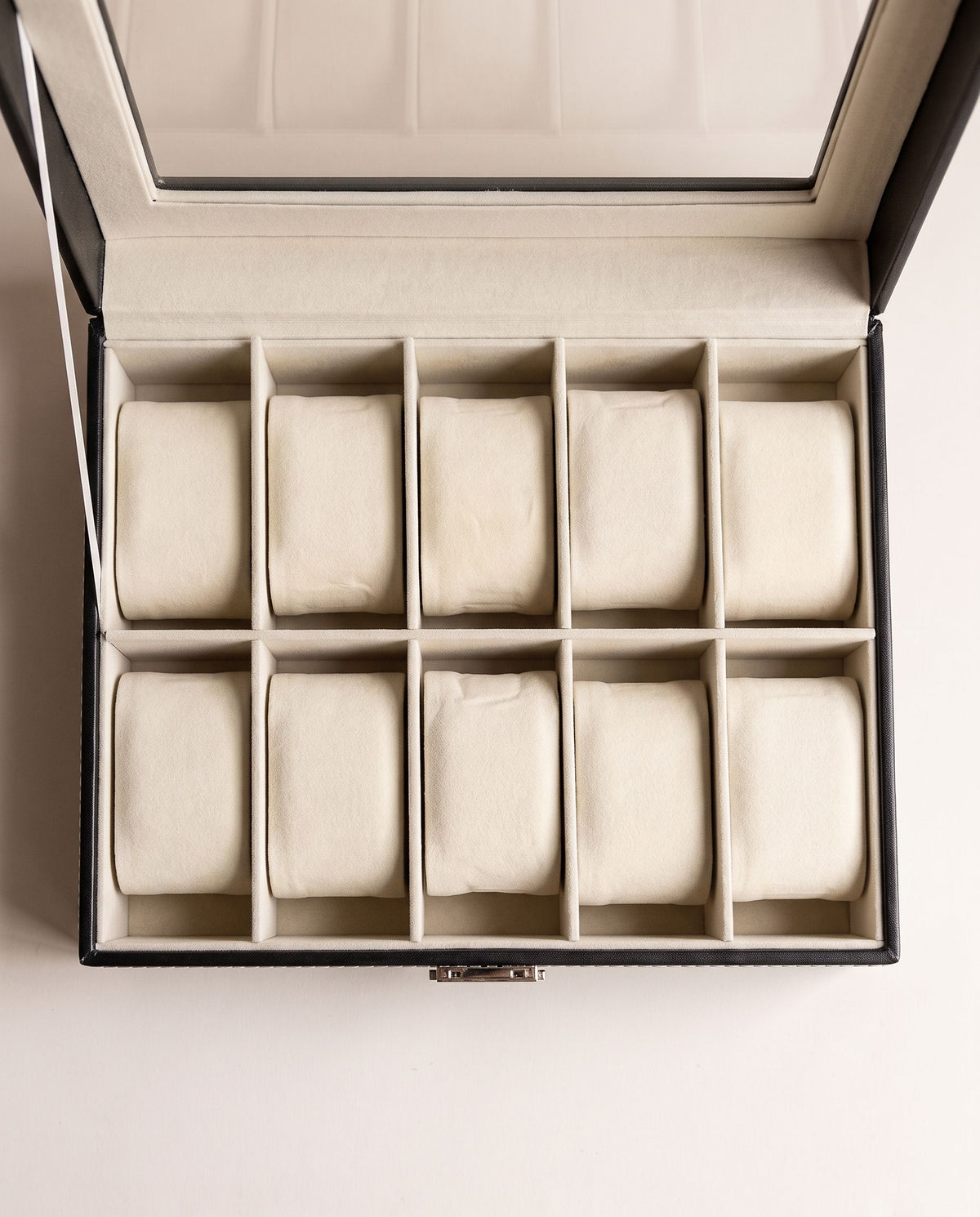 Overhead view of the 10 cream cushions in two rows of five inside the watch box