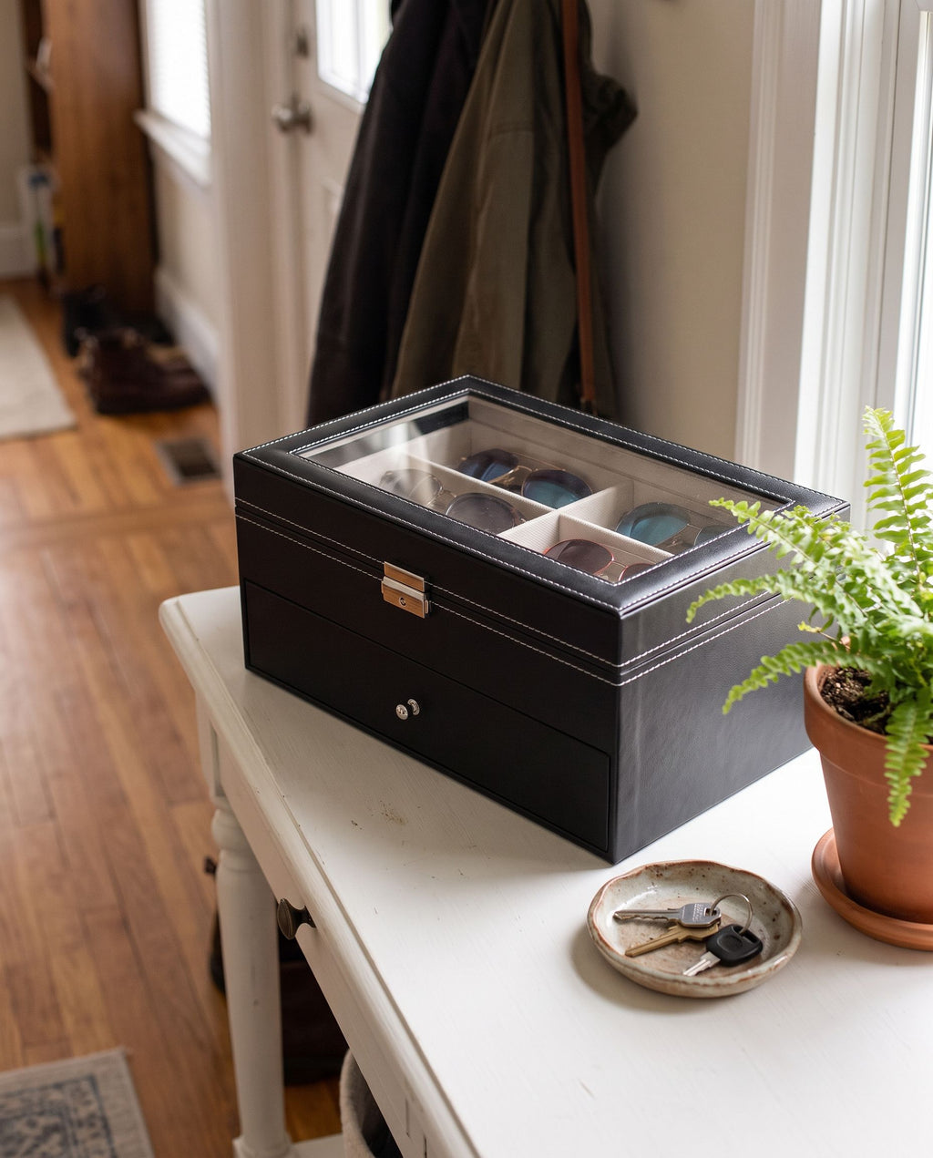 Eyewear organizer closed on an entryway console, sunglasses visible through the glass lid (eyewear not included)