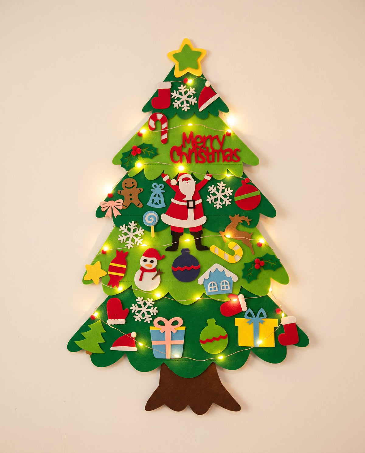 Felt Christmas wall tree with felt ornaments, star and warm LED string lights on an off-white wall