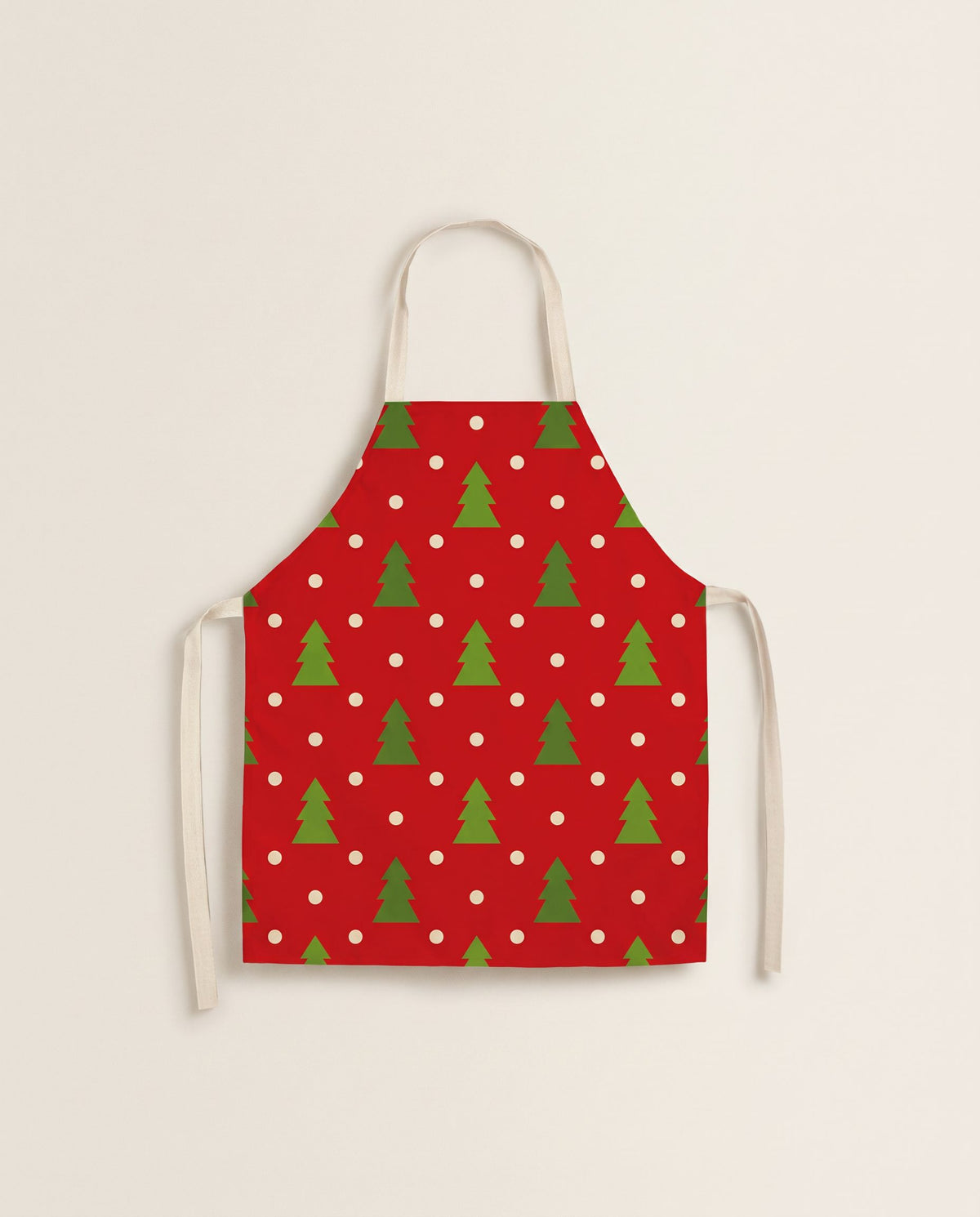 Red kitchen apron printed with small green Christmas trees and white dots