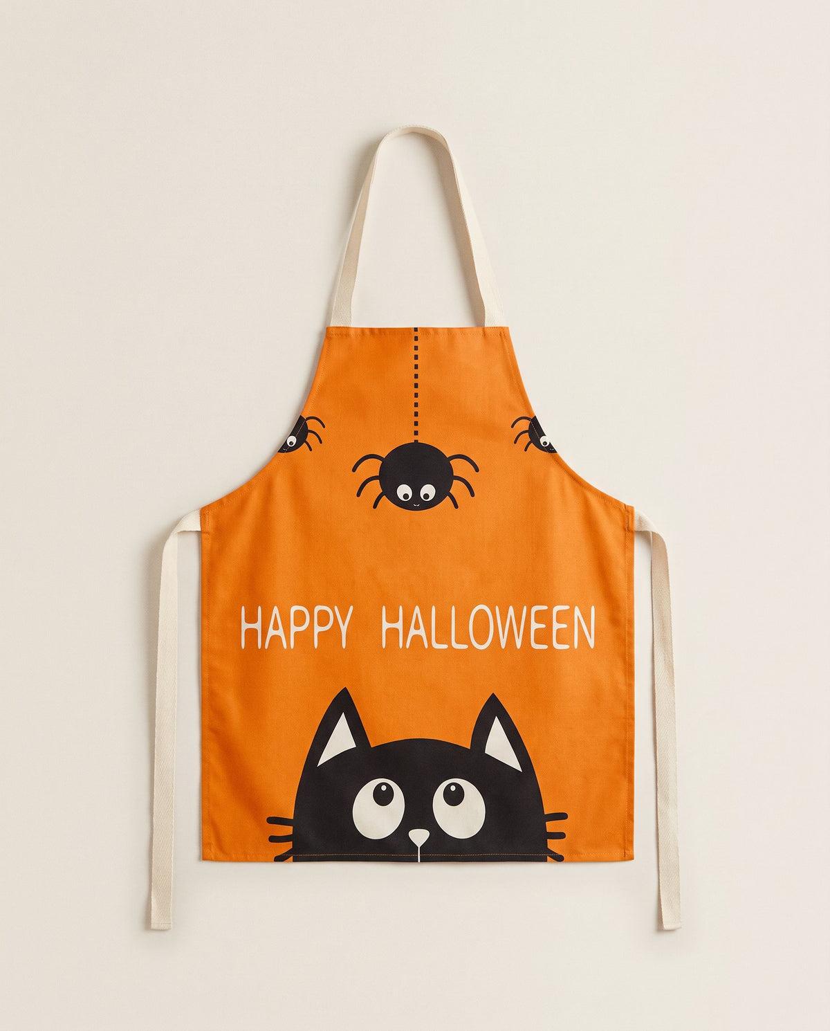 Orange Halloween kitchen apron with hanging spiders, HAPPY HALLOWEEN text and a peeking black cat