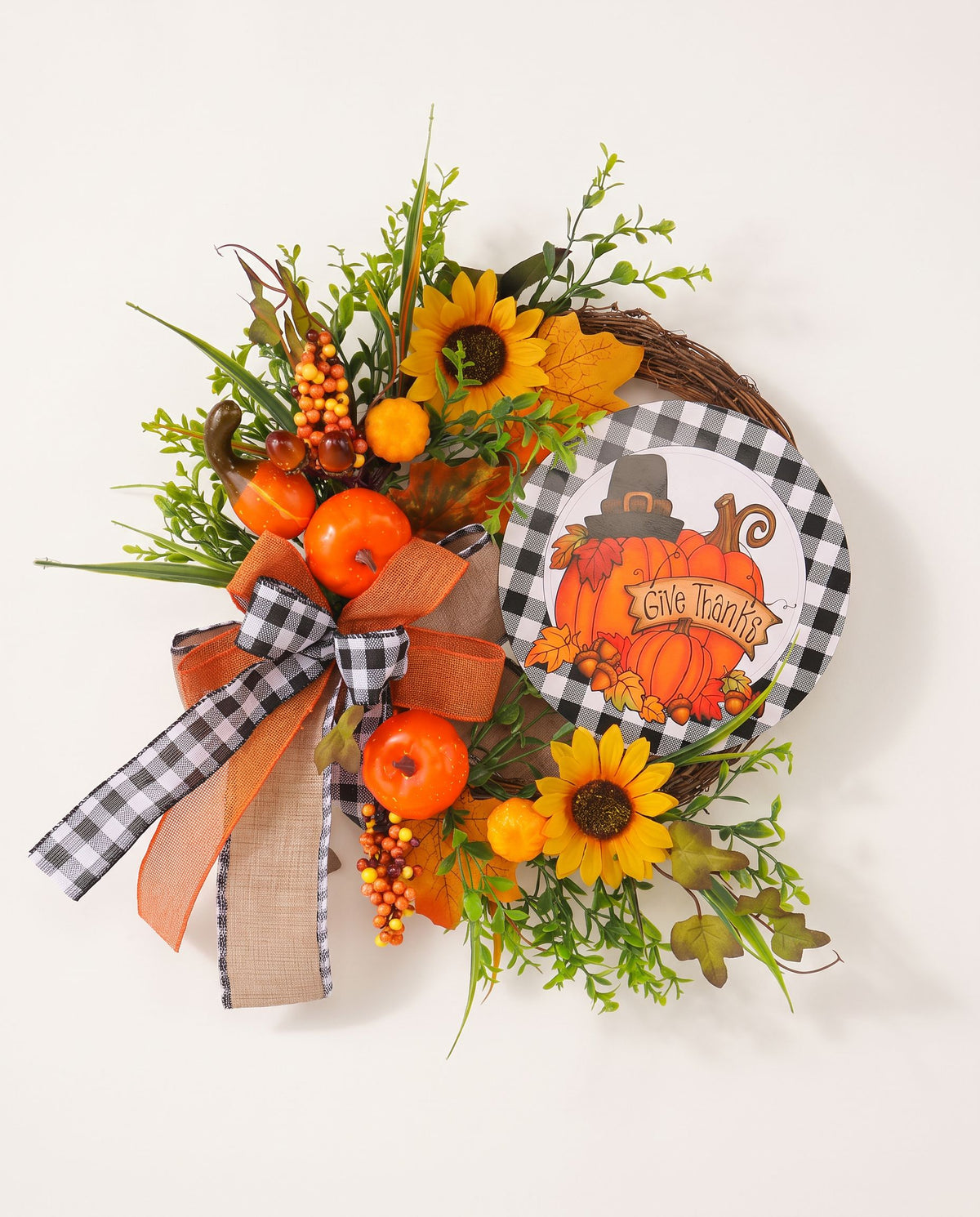 Harvest wreath with orange pumpkins, sunflowers, greenery, buffalo-check bow and a round Give Thanks pumpkin sign