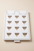 White clothes folding board lying flat and closed, twelve triangular cut-outs