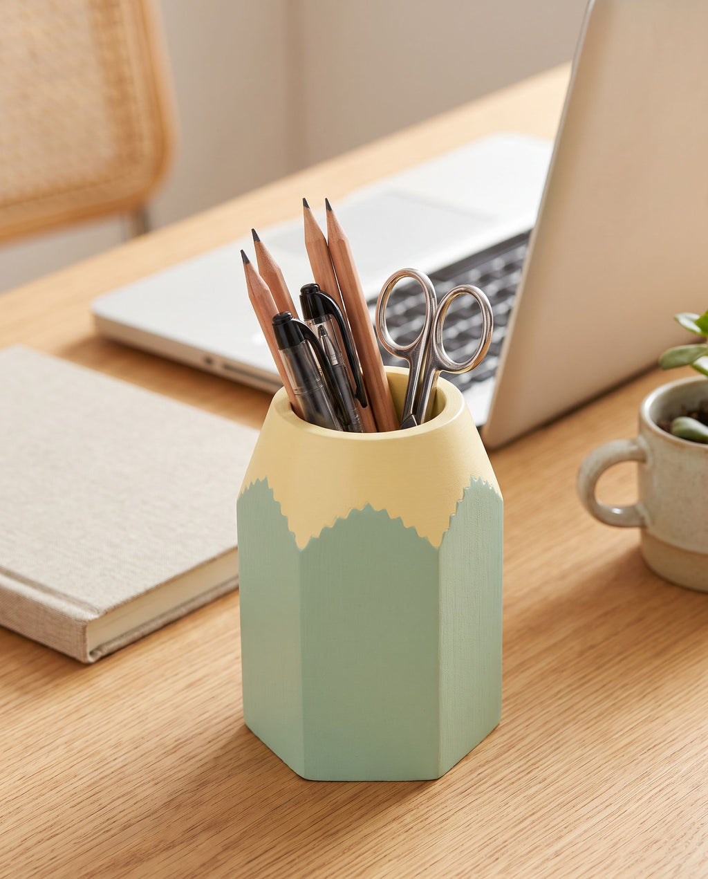 The holder on a home-office desk holding pens, pencils and scissors upright