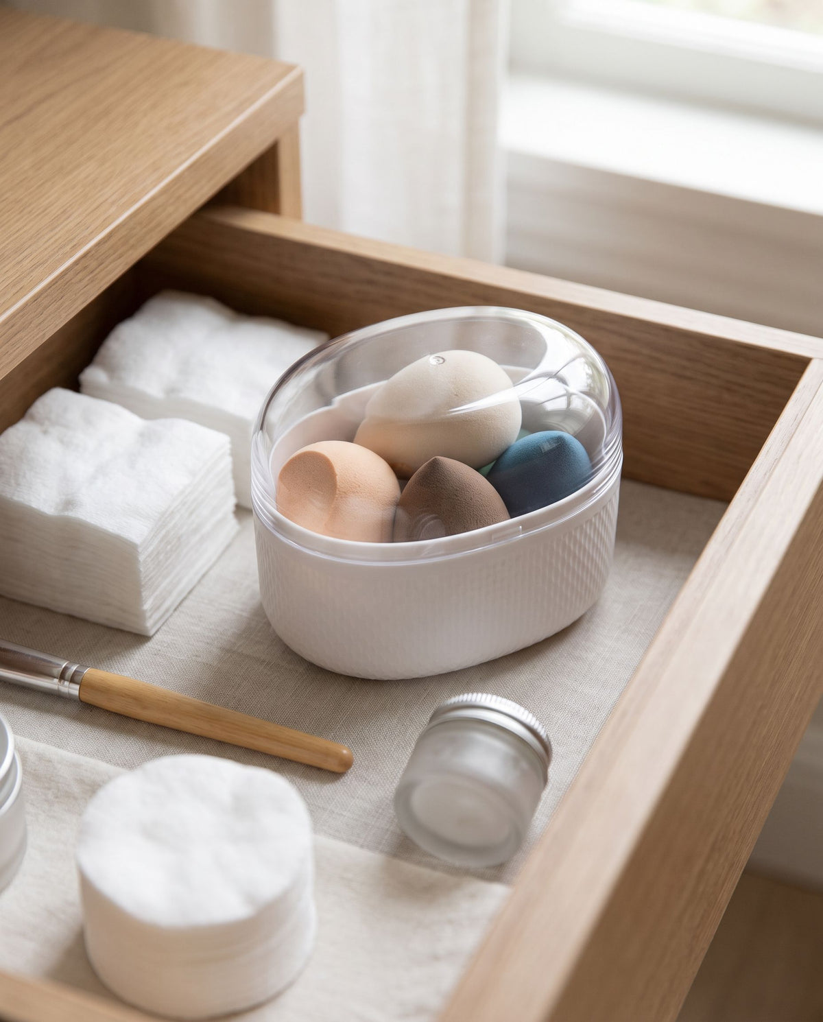 The box inside an open vanity drawer among other small items