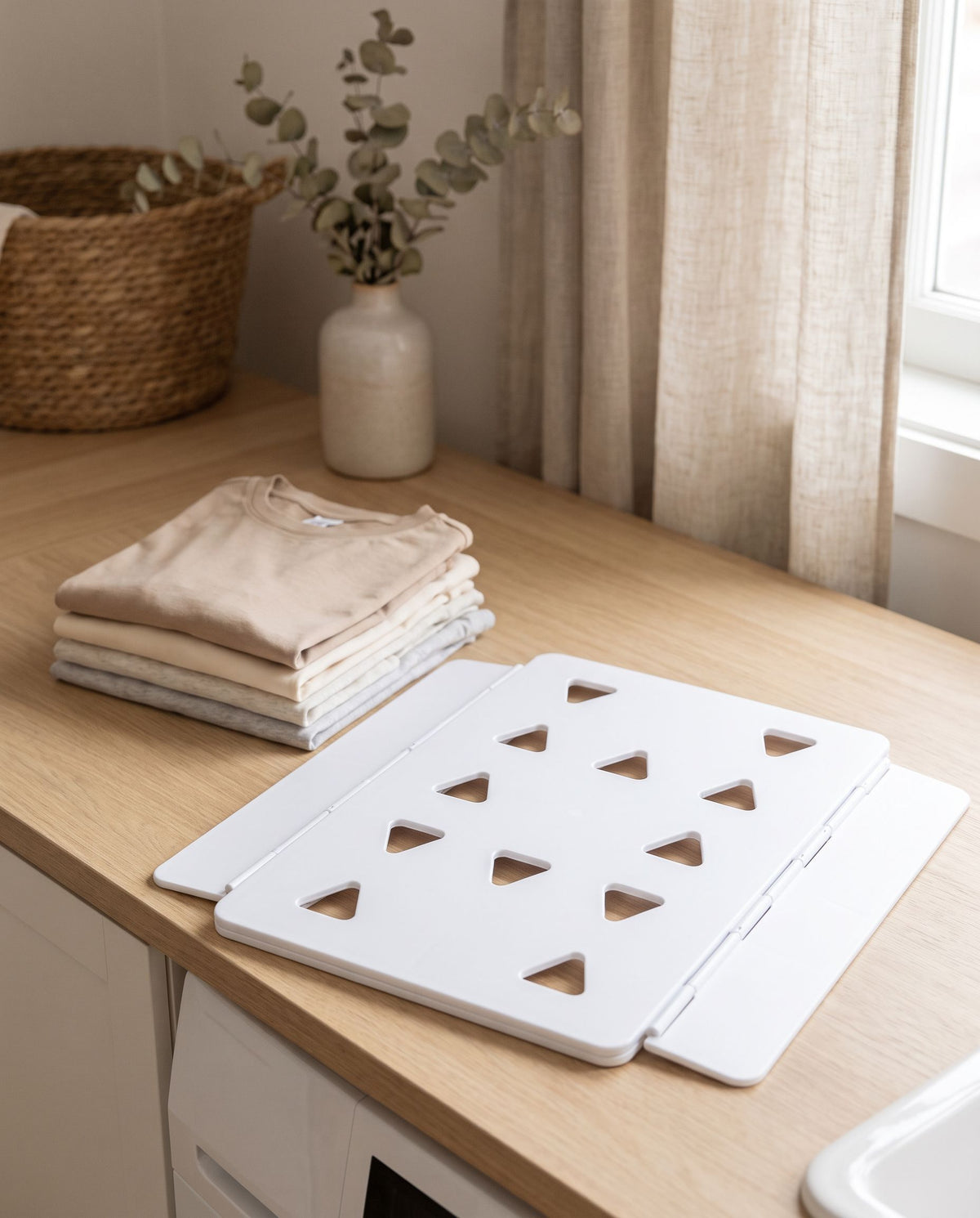 The folding board beside a stack of evenly folded shirts